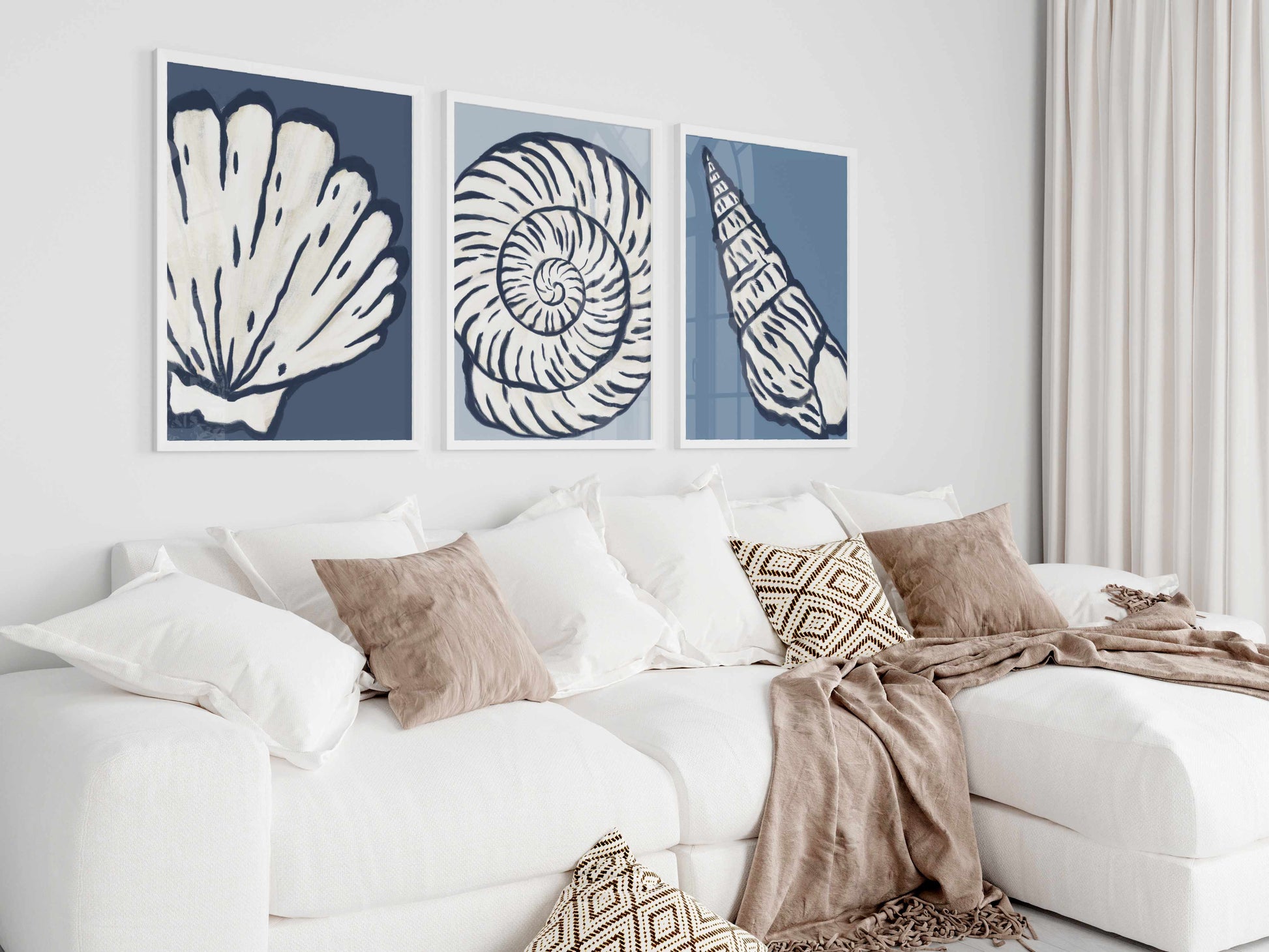 a living room with a white couch and two paintings on the wall